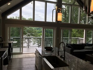 Un'ampia cucina con grandi finestre, un'area pranzo e vista su un lago.