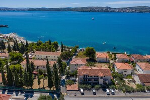 Un pueblo costero con edificios residenciales, una playa y un barco en el agua.