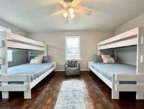 Cozy room with a central seating area and two bunk beds, each with a nightstand.