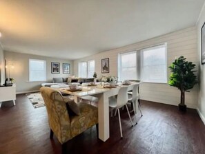 Relax in this inviting living area with a dining table for four, comfortable seating, and a large window.