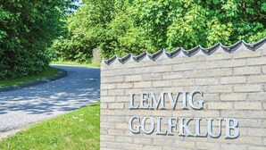 Un muro de ladrillo con el texto "LEMVIG GOLFCLUB", que indica un club de golf.