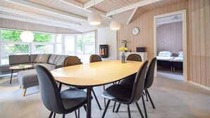 Ein modernes Wohnzimmer mit einem runden Tisch, schwarzen Stühlen, einer Couch und einem Kamin.
