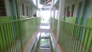 A corridor with green railings and a tiled floor, leading to a staircase. - Green Court Hotel (Bondo)