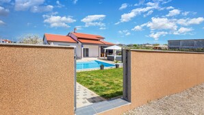 A modern house with a swimming pool, a covered patio, and a view of the neighborhood. - Beautiful home in Pula (Pula)