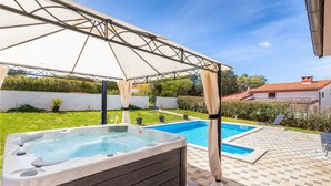 A backyard with a hot tub, a swimming pool, and a covered patio area. - Beautiful home in Pula (Pula)