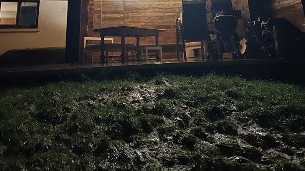 Un dormitorio en el ático con techo inclinado, una araña, una mesa y una silla.