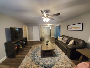 Relax in this stylish living room with a flat-screen TV, comfortable sofa, and a coffee table.