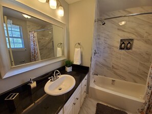Combined shower/bathtub, hair dryer, towels, toilet paper