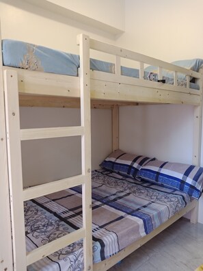A bunk bed with a lower bunk and a top bunk, both with patterned bedding.