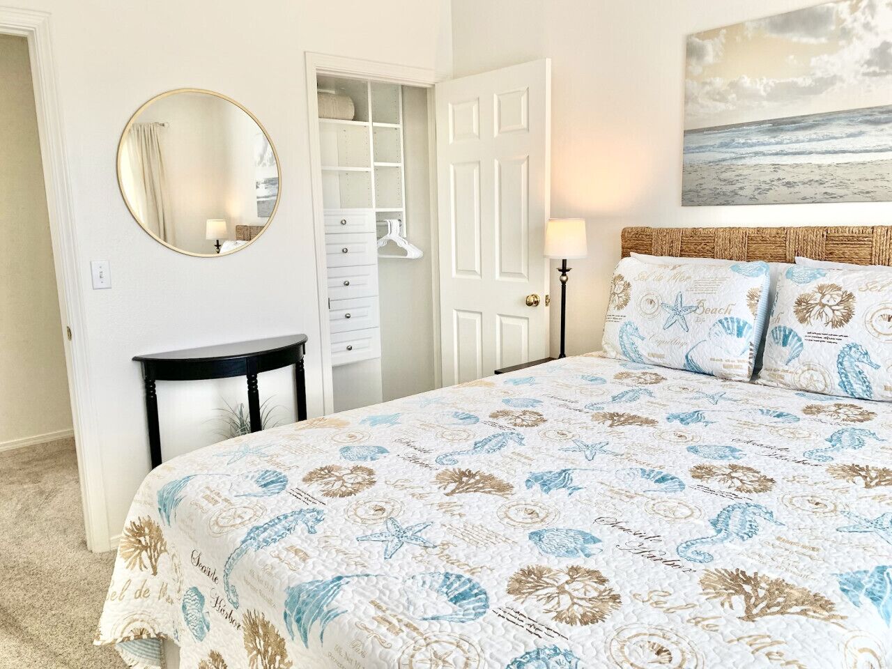 A bedroom with a bed, a dresser, a mirror, and a door.