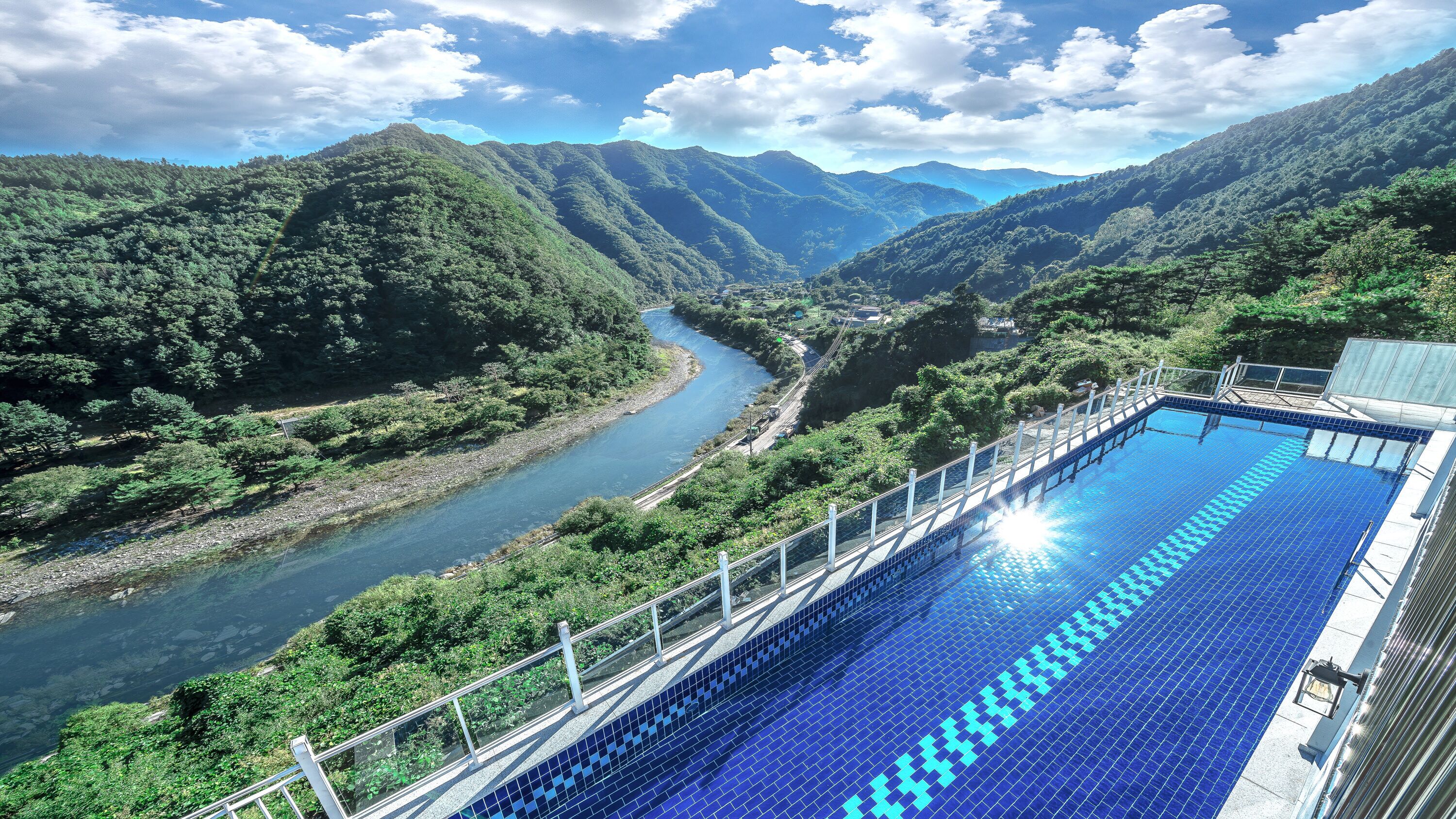 Une piscine avec vue sur une rivière et des montagnes.