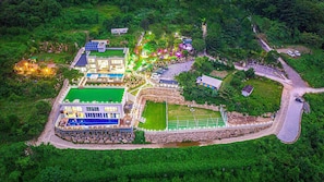 An aerial view of a resort with multiple buildings, a swimming pool, and landscaped gardens. - Miramonti Pool Villa Pension (Gapyeong)