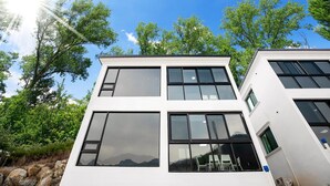 Un immeuble moderne à plusieurs étages, doté de grandes fenêtres et d’une façade blanche.