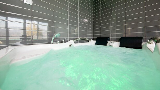 Une salle de bain moderne avec une grande baignoire, une douche et des toilettes.