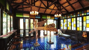 Una habitación con piso de baldosas, techo de madera y una gran escultura decorativa.