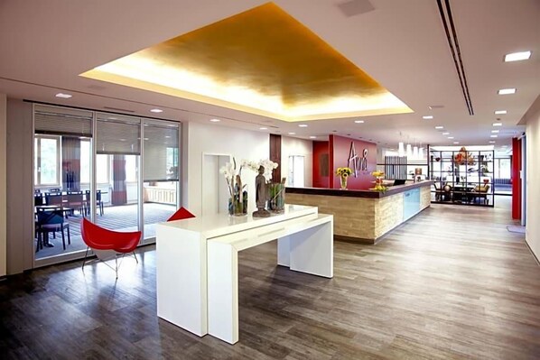 Un intérieur moderne comprenant un comptoir d’accueil, un espace détente et une vue sur l’extérieur.