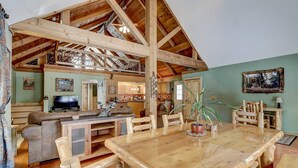 Interior rústico de una cabaña con comedor, cocina y sala de estar.