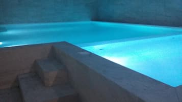 Una piscina al aire libre, sillones reclinables de piscina