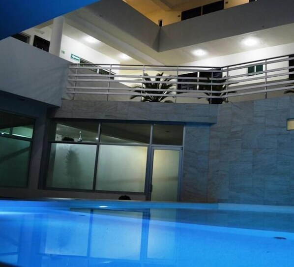 Una piscina al aire libre, sillones reclinables de piscina