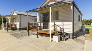 A row of mobile homes with covered porches and outdoor seating areas.