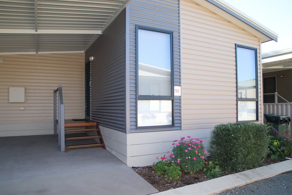 A single-story building with a covered entrance and a small set of stairs leading up to the door.