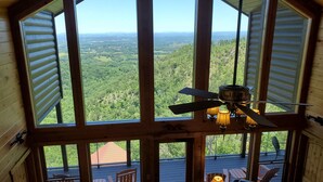 Una cabaña con amplias ventanas que ofrece vistas de un paisaje boscoso.