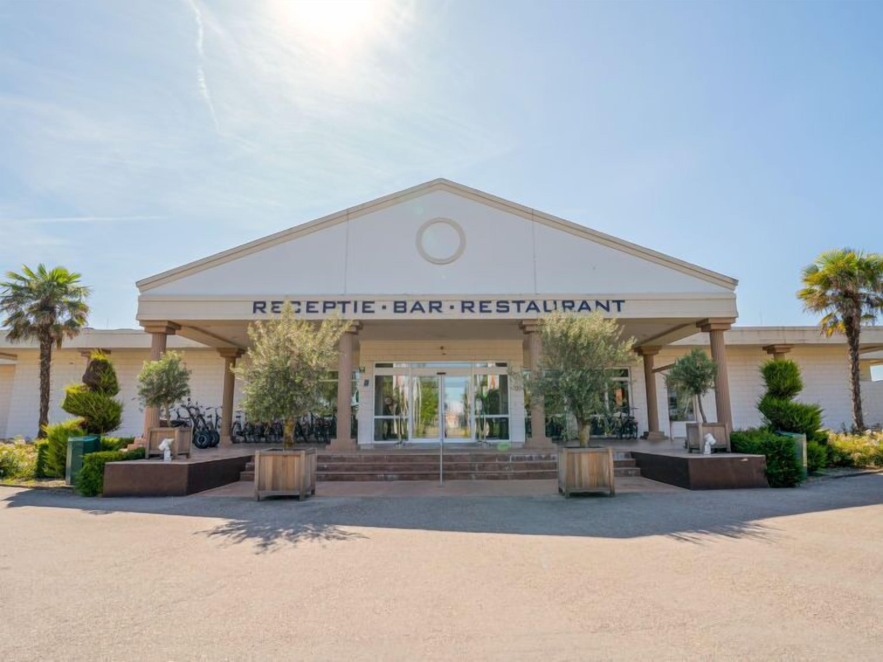 A reception area with a sign reading "RECEPTION BAR RESTAURANT" above the entrance.