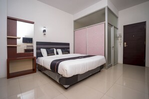Relax in a spacious bedroom with a large bed, flat-screen TV, and ample storage.
