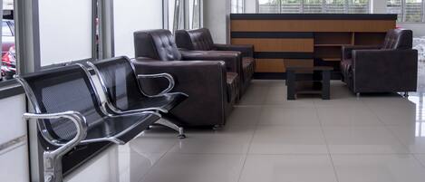 A waiting area with leather chairs and a reception desk.