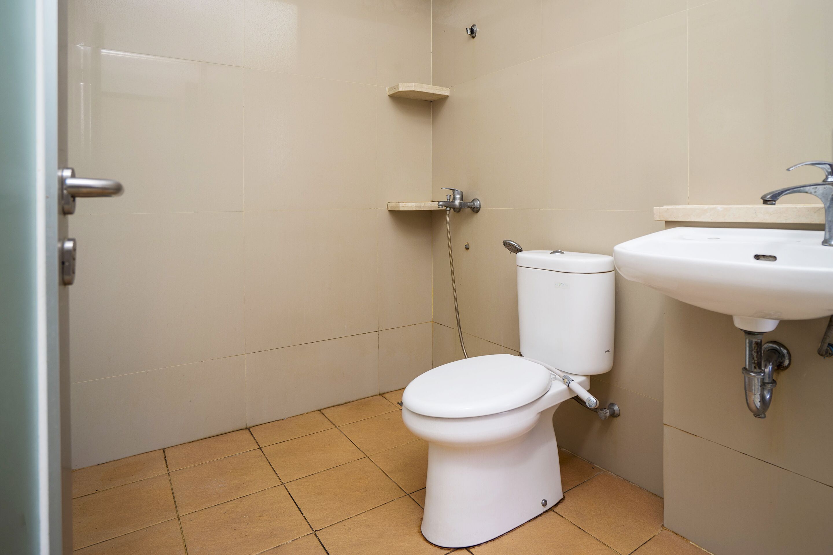 A small bathroom with a toilet, sink, and shower.