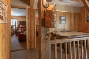 Una habitación acogedora con billar, paredes de madera y un letrero que dice 'THIS IS THE LIFE'.