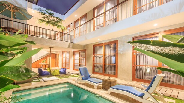 Zona de piscina con sillas de descanso, una escalera y un balcón con vistas.