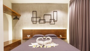 Una cama bien hecha con un diseño de cisne en las toallas, un cabecero de madera y una obra de arte en la pared.