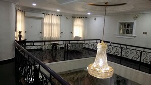 A hotel room with a balcony, a chandelier, and a window with curtains. - Exquisite home. Perfect home away from home (Lagos Mainland)