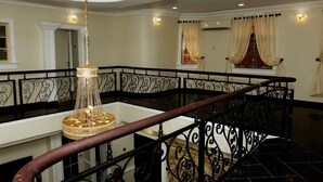 A grand staircase with ornate black railings and a chandelier. - Exquisite home. Perfect home away from home (Lagos Mainland)