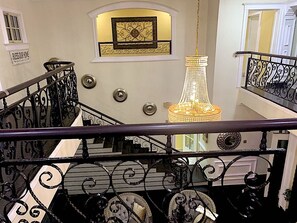 A grand staircase with ornate black railings and a chandelier. - Exquisite home. Perfect home away from home (Lagos Mainland)