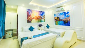 A hotel room with a bed, a chair, and two large paintings of cityscapes. - Venice Hotel (Ho Chi Minh City)