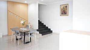 Una zona d'esbarjo modern amb un armari de fusta, una escala i un quadre encimbellat a la paret.