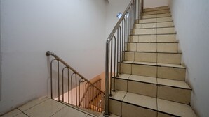 A staircase with metal railings and beige tiles.