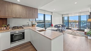 Una cocina moderna con horno integrado y comedor con mesa redonda y sillas.