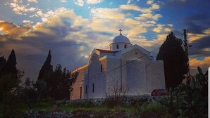 A church with a dome and cross, surrounded by cypress trees and a clear sky. - Theodos Lodge Hotel By Hansa (Batroun)