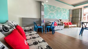 A modern living room with a sofa, chairs, and a patterned wall. - SPOT ON 90283 27 Muntri (George Town)