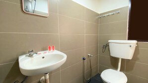 A bathroom with a white sink, mirror, and toilet. - SPOT ON 90283 27 Muntri (George Town)