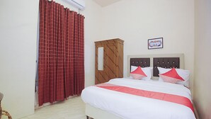 A bedroom with a bed, a wardrobe, and a curtain. - Hotel O Diva Residen Syariah (Jambi)