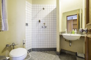 A bathroom with a toilet, shower, and sink. - Super OYO Collection O 25 Hotel Baltika (Bandung)