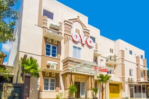 A hotel with a prominent 'OYO' sign, a covered entrance, and palm trees in front. - Hotel O D'soetta (Malang)