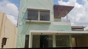 A two-story building with a balcony, large windows, and a solar panel on the roof. - OYO 2753 Irma's Residence (Blitar)