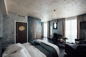 A modern hotel room with a large bed, a desk, and a seating area. - Amirauté (La Baule-Escoublac)