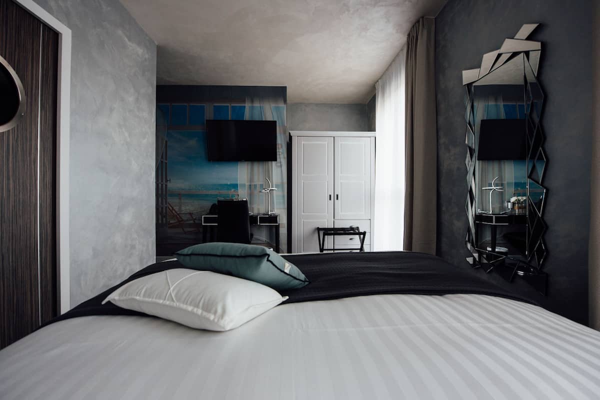 Quarto moderno com uma cama grande, uma escrivaninha e um guarda-roupa.