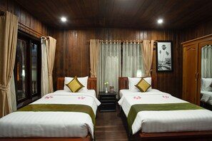 A hotel room with two beds, wooden walls, a window with curtains, and a framed picture on the wall. - ChampeySor Angkor Boutique Hotel (Siem Reap)